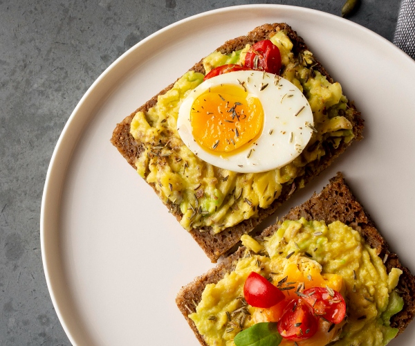 Tostadas de aguacate, huevos y tomates. Desayunos saludables.