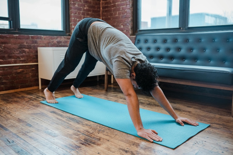 Hombre practicando yoga para principiantes en su casa.